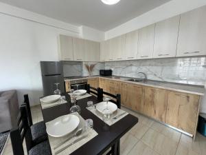 a kitchen with white cabinets and a black counter top at Moon City Center Apartment in Shkodër