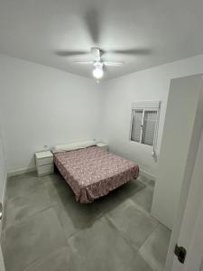 ein Schlafzimmer mit einem Bett und einem Deckenventilator in der Unterkunft Casa Ianira in El Puerto de Santa María