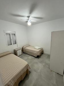 Zimmer mit 2 Betten und einem Deckenventilator in der Unterkunft Casa Ianira in El Puerto de Santa María
