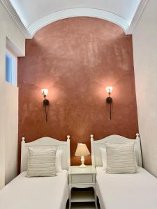 two beds in a room with a red wall at Charming of Olhao2 in Olhão