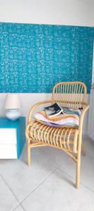 un banco de ratán en una habitación con una pared azul en Casa Milo, en Deiva Marina