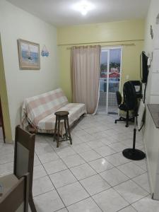 a bedroom with a bed and a desk and a television at Apartamento Estrela da Praia V19 in Mongaguá