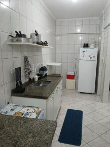 a kitchen with a sink and a refrigerator at Apartamento Estrela da Praia V19 in Mongaguá