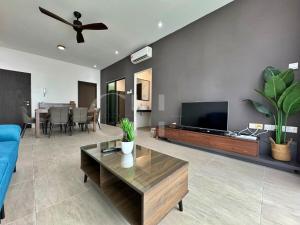 a living room with a blue couch and a flat screen tv at Kuching Rex 2 bedrooms for 4 pax in Kuching