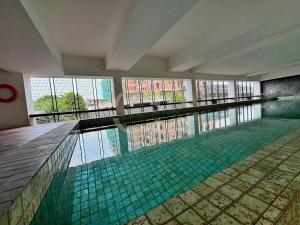 a large swimming pool with water in a building at Kuching Rex 2 bedrooms for 4 pax in Kuching