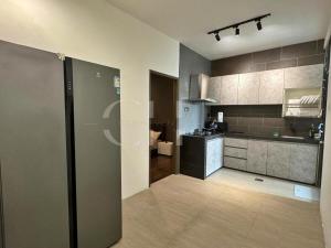 a kitchen with a refrigerator in the middle of a room at Kuching Rex 2 bedrooms for 4 pax in Kuching