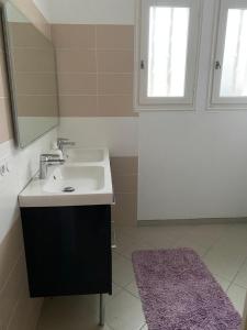 a bathroom with a sink and a mirror at Les sorbiers in Crozon