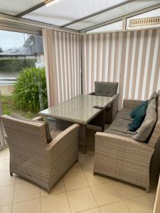 a patio with a table and two chairs and a window at Les sorbiers in Crozon
