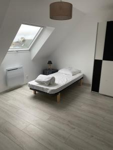 a white room with a bed and a window at Les sorbiers in Crozon +4 photos