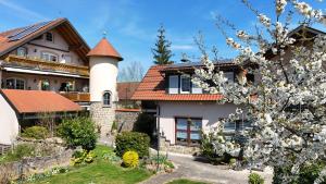 a house with a turret and a flowering tree at Pension Göppner in Salz