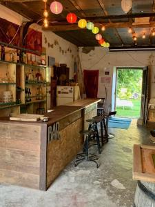 a kitchen with a counter and stools in a room at Gîte Vanakam 3 étoiles- jolie maison béarnaise 9 personnes avec piscine in Sault-de-Navailles