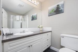 Un baño blanco con lavabo y espejo. en Paradise Canyon Golf Resort - Signature Villa 380, en Lethbridge 18 fotos más