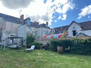 a yard with a chair and an umbrella and buildings at Maison Henriette in Léré