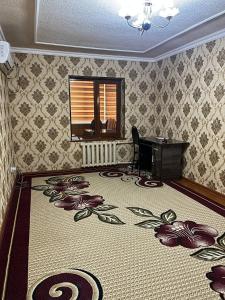 a room with a desk and a carpet with flowers on it at Aile Bukhara in Bukhara