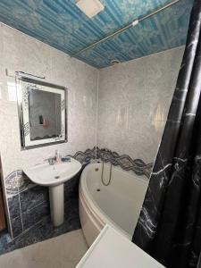 a bathroom with a sink and a tub and a toilet at Aile Bukhara in Bukhara