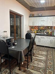a kitchen with a table and chairs in a kitchen at Aile Bukhara in Bukhara