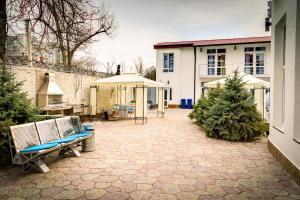 a patio with two chairs and an umbrella at Apartments & Villa Georg in Odesa