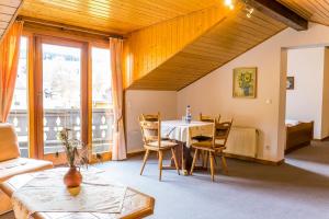 ein Wohnzimmer mit einem Tisch und Stühlen sowie einem großen Fenster in der Unterkunft Waldhotel in Kaltenborn