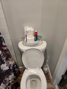 a bathroom with a toilet with a plate on top of it at Agape queen room 6D in Newark