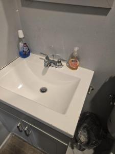 a bathroom sink with soap and a soap bottle on it at Agape queen room 6D in Newark