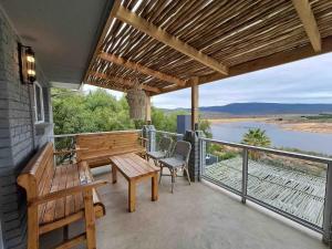 a patio with a table and chairs on a balcony at Clanwilliam Dam House in Clanwilliam