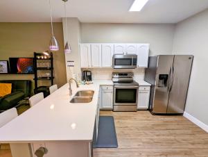 a kitchen with white cabinets and stainless steel appliances at New Luxury Townhome near Disney in Orlando