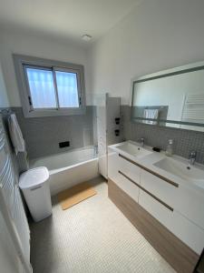 un bagno con vasca, lavandino e specchio di Villa 4* Proche centre et plage. Animaux bienvenus a Meschers-sur-Gironde Altre 30 foto