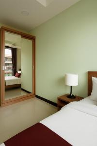a hotel room with a bed and a mirror at 1 bedroom Naiharn Beach Condo in Rawai Beach +6 photos