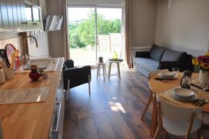 a kitchen and living room with a couch and a table at Le Séchoir, au Jardin des Tisanes in Tabanac
