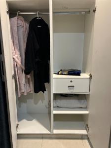vestidor con armario blanco y ropa en 1BHK Cozy Appartment, en Rawalpindi 4 fotos más
