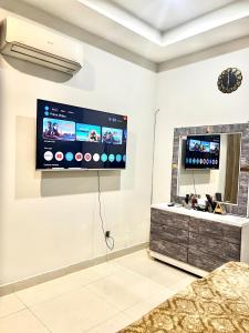 Una sala de estar con un televisor de pantalla plana en la pared. en 1BHK Cozy Appartment, en Rawalpindi