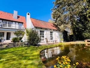 a house with a pond in the yard at Ferienhaus Lüneburger Heide mit Therapiemöglichkeit in Jelmstorf