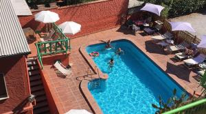 an overhead view of a swimming pool with people in it at Alina Villa with shared pool in Montecatini Terme