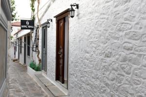 a white building with a door and a sign on it at Sidra Hotel in Hydra