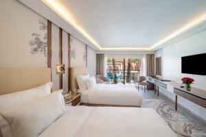 a hotel room with two beds and a television at Savoy Le Grand Hotel Marrakech in Marrakech