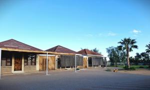 a group of buildings with palm trees in the background at Duineveld Self Catering Cottage in Kalkrand +2 photos