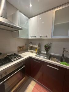 a kitchen with white cabinets and a sink and a stove at Luxury suite jardin de Carthage in Sidi Daoud