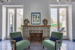 a living room with two chairs and a fireplace at Hotel Mignon Meublè in Sorrento