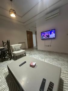 a living room with a tv and two remote controls on a table at Luxury suite jardin de Carthage in Sidi Daoud