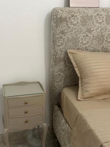 a bed with a night stand next to a bed with a drawer at Luxury suite jardin de Carthage in Sidi Daoud