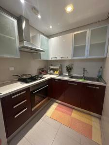 a kitchen with brown cabinets and a sink and a stove at Luxury suite jardin de Carthage in Sidi Daoud +5 photos