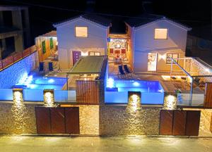 a house with a swimming pool at night at Zante way villas in Alikanas