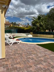 a swimming pool with two lawn chairs and a table at Casa El Mirador in Viña de Raja