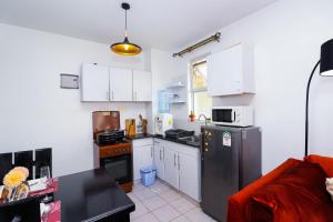 a kitchen with white cabinets and a stainless steel refrigerator at Classy One Bedroom Along Ngong Road in Nairobi