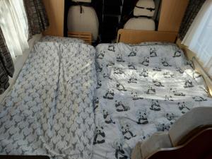 a bed with a comforter on top of it at A vroom with a view! in Eastcote