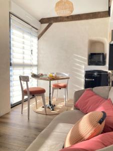 a living room with a table and a couch at Le petit Grenier de la Fontaine in Vignoc