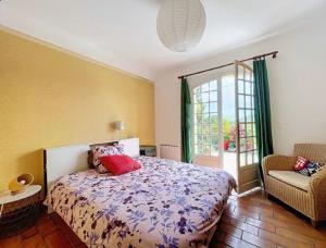 a bedroom with a bed and a chair and a window at Maison de famille en Provence in Rognes