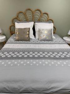 a bed with white stars on it with two pillows at Appartement Cosy Le Lys Vert à 40mn de Paris in Dammarie-lès-Lys