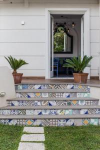 uma casa com uma escada em mosaico com plantas em Hotel Mignon Meublè em Sorrento