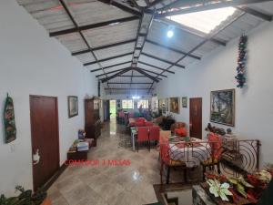 a room with a living room with tables and chairs at Alojamiento campestre CASA GRANDE Guateque Hospedaje in Guateque